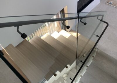 Glass wall panels for staircase | stainless steel handrails | matte black powder coated | contemporary stainless solutions